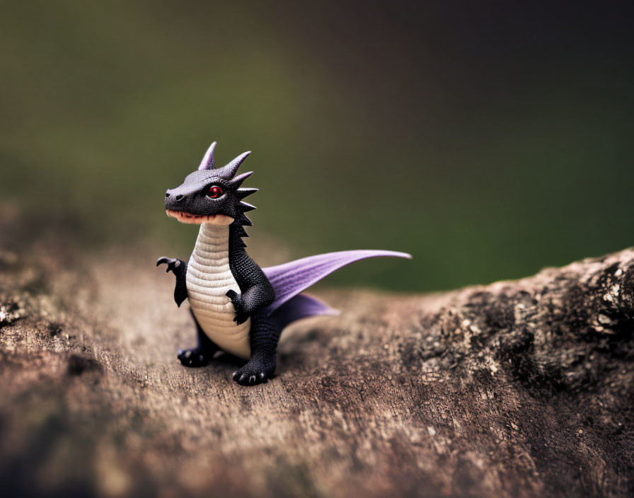 Black and White Toy Dragon with Purple Wings on Wooden Surface