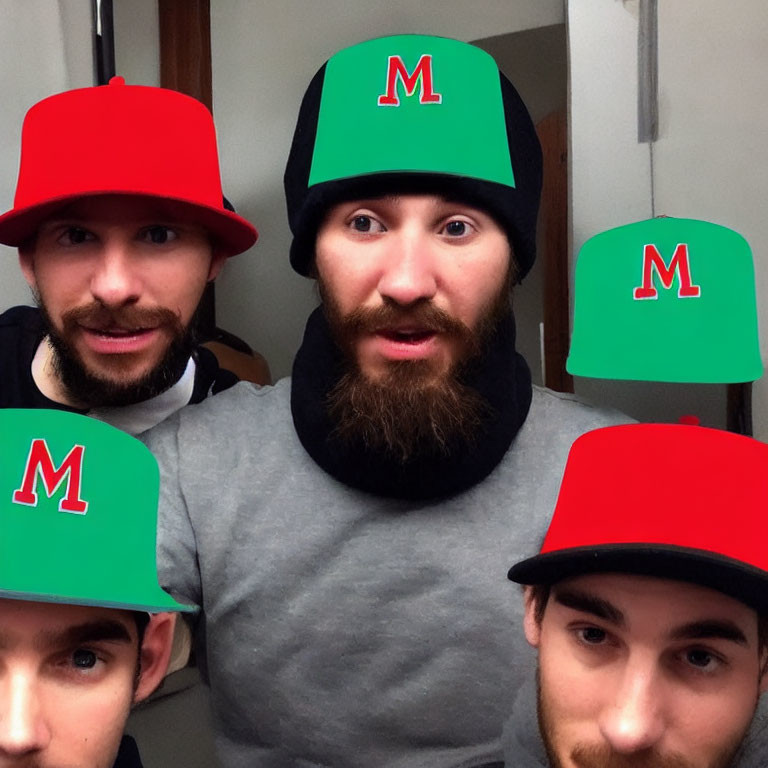 Four Men in Red and Green Hats with 'M' Letter in Small Room