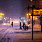 Snowy Street Night Scene with Glowing Streetlights and People Walking