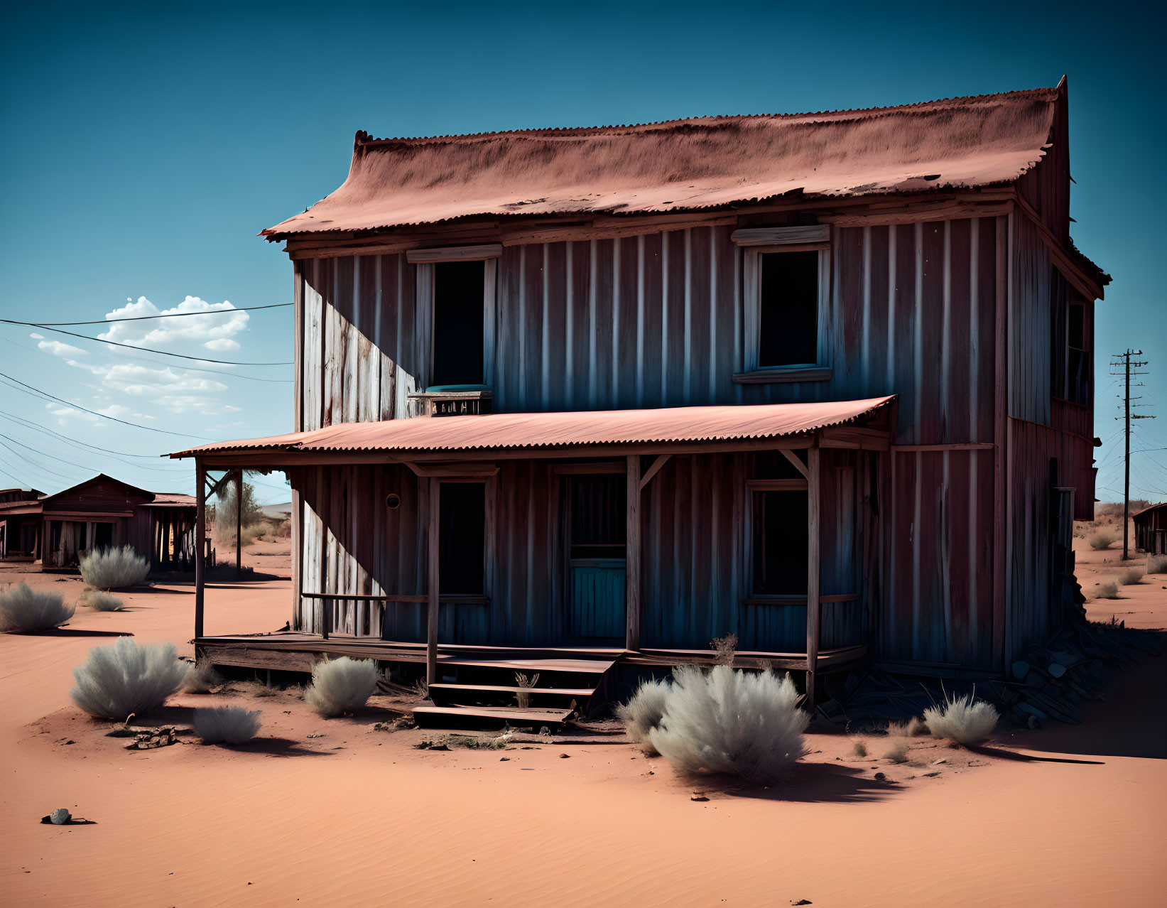 Rustic two-story corrugated metal house in desert landscape