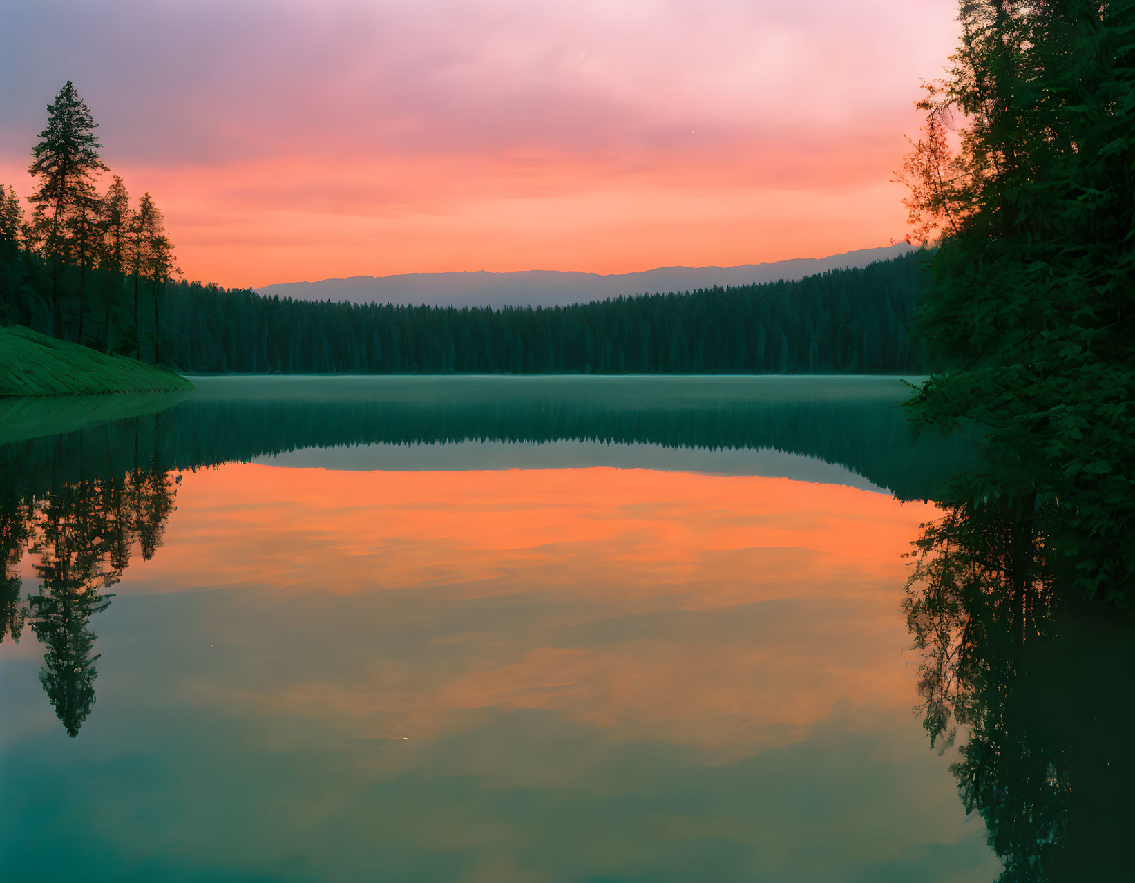 Tranquil Sunset Scene: Orange and Pink Sky Reflecting on Still Lake