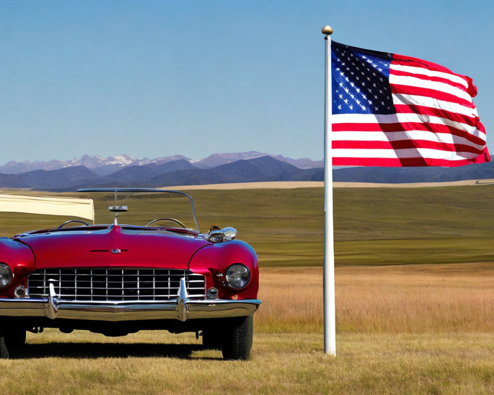 Classic Red Car Parked Next to American Flag Under Blue Sky and Mountains