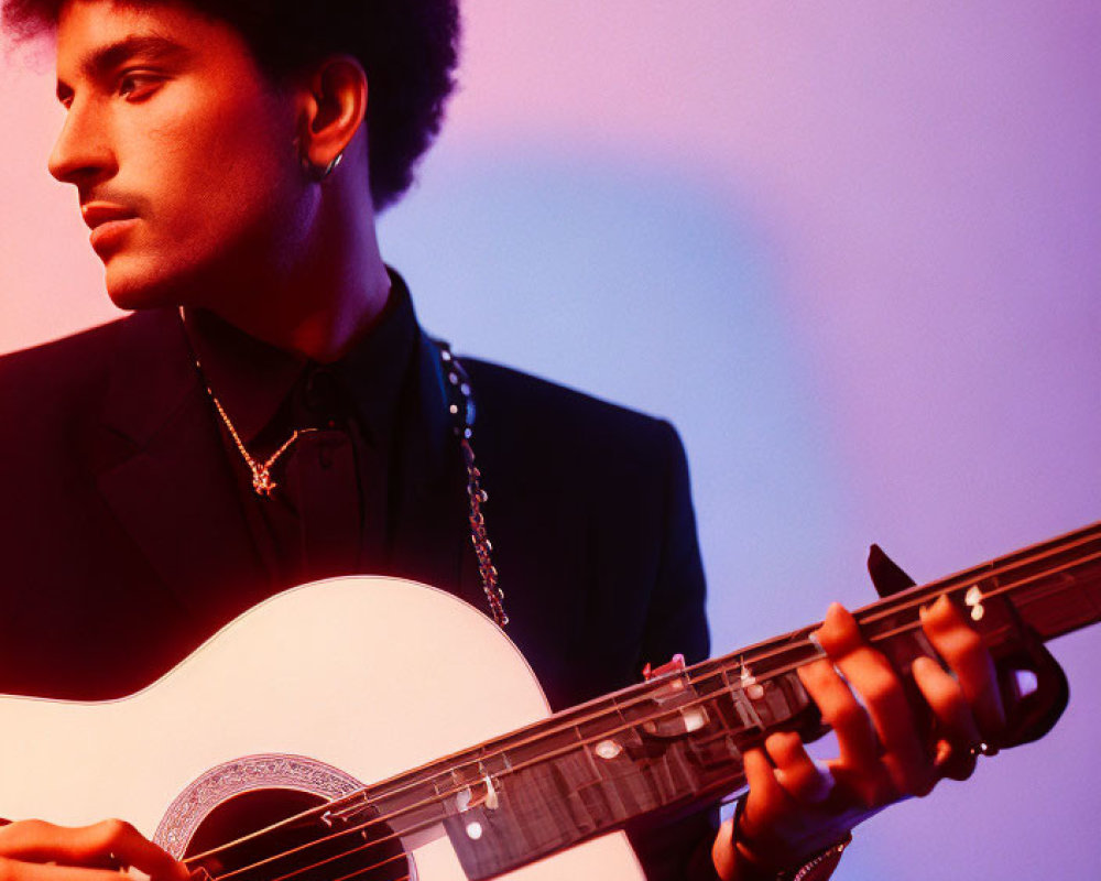 Person with Afro Playing Acoustic Guitar in Pink and Purple Lighting