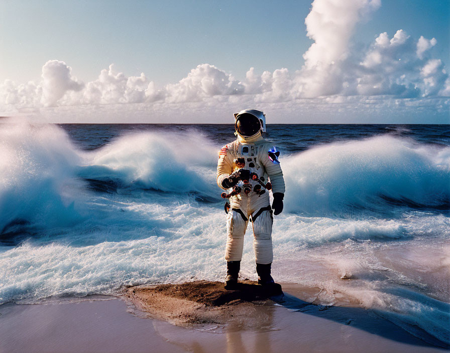 Astronaut in full space suit on sandy beach with crashing waves on sunny day