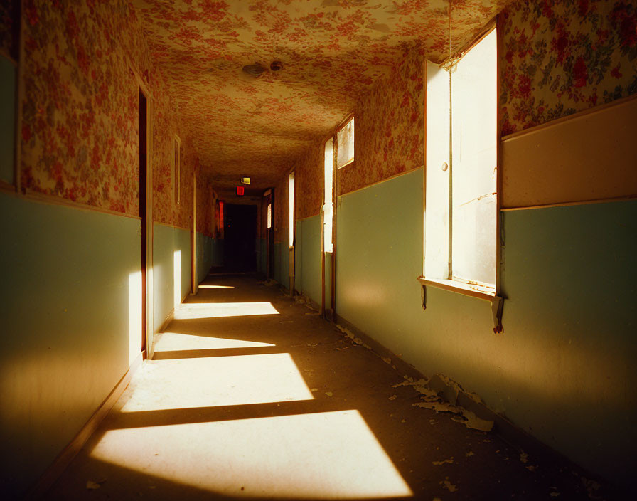 Desolate corridor with peeling wallpaper and open window