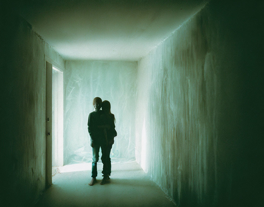 Silhouette of a person in dimly lit hallway with plastic sheeting