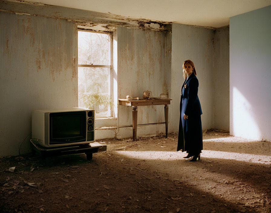 Abandoned room with peeling walls, vintage TV, and natural light.