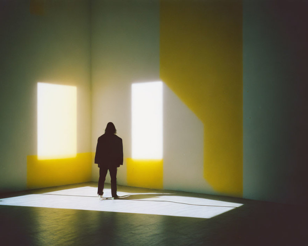 Silhouette of a Person in Minimalist Room with Yellow Light and Sharp Shadows