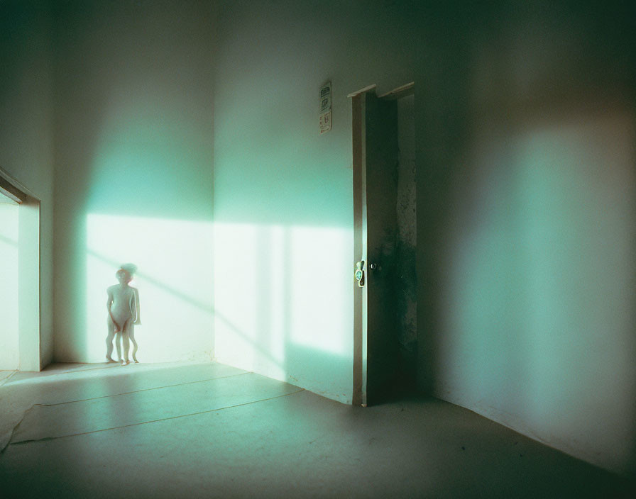 Child in dimly lit room with strong shadows from doorway