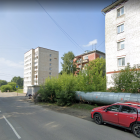 Desolate urban street with decaying buildings and rusty cars in foggy setting