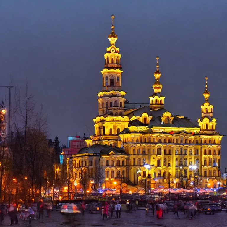 Ornate multi-tiered building at twilight with people milling around