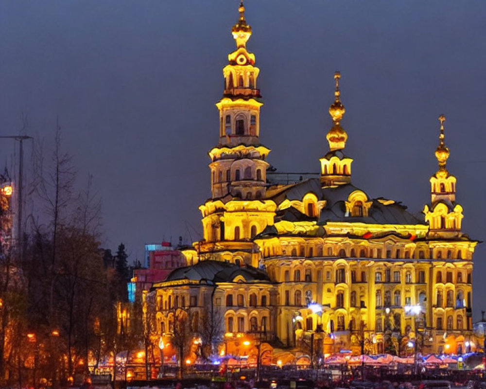 Ornate multi-tiered building at twilight with people milling around