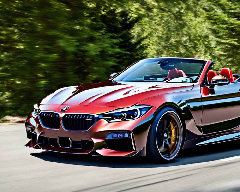 Red BMW Convertible with Black Grill and Rims Driving on Tree-Lined Road