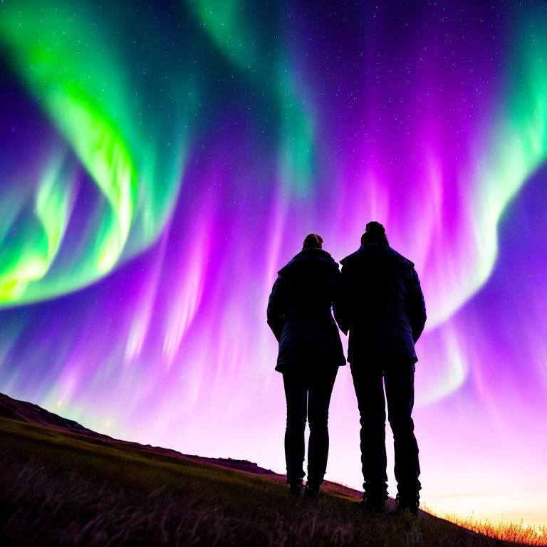 Silhouetted couple under vibrant aurora borealis