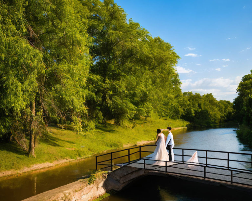 Wedding couple on bridge over tranquil river with lush green trees