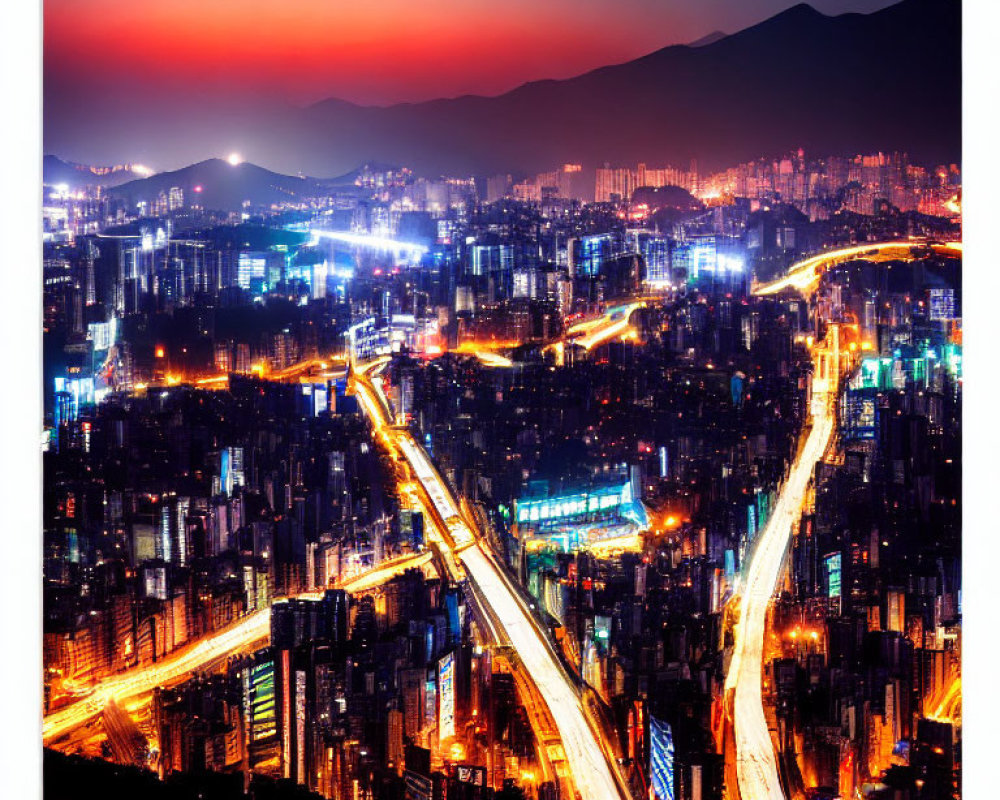 Twilight cityscape with illuminated streets, buildings, and mountains