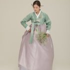 Traditional Korean hanbok with delicate floral designs on a woman against beige background