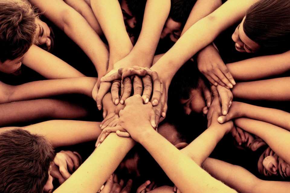 Group of People Showing Unity with Crossed Arms and Piled Hands