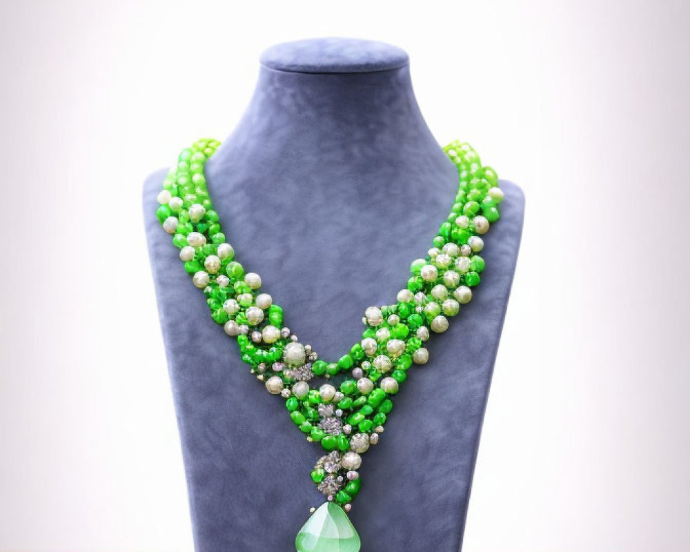 Green and White Beaded Necklace with Large Green Pendant on Gray Bust