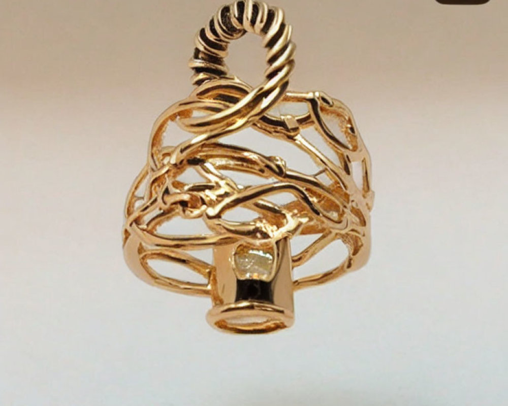 Intricate golden cage pendant with looping wire designs on beige background