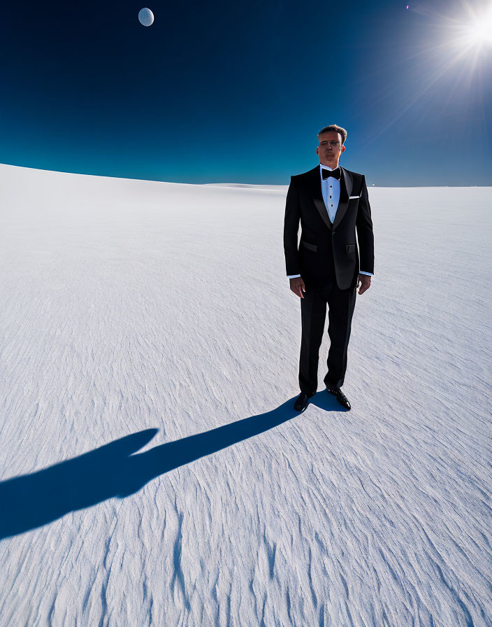 Man in tuxedo on snowy landscape under bright sky with sun and moon