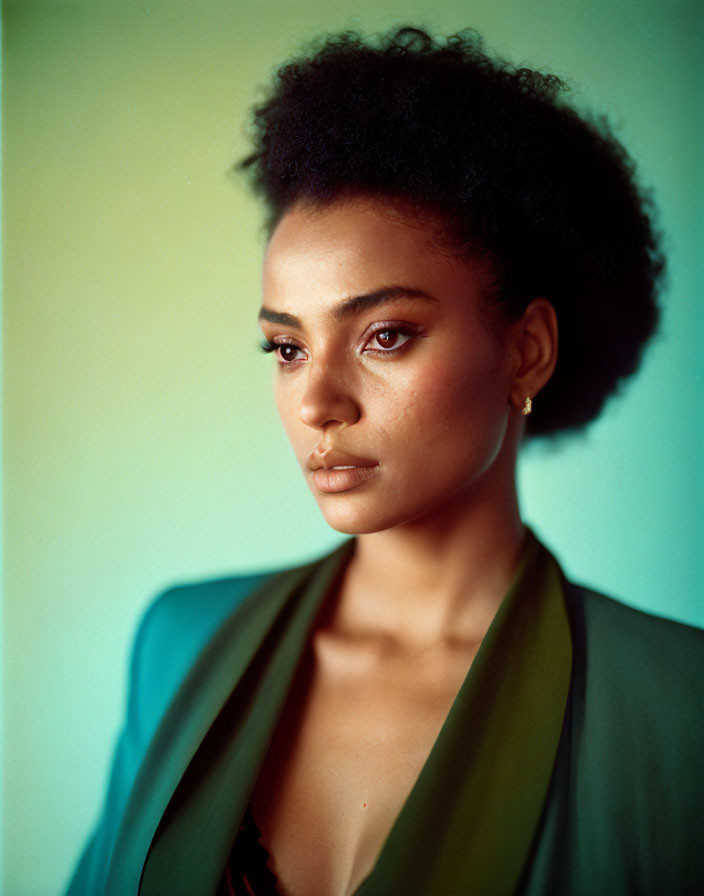 Woman with Afro in Green Jacket Portrait on Soft Green Background