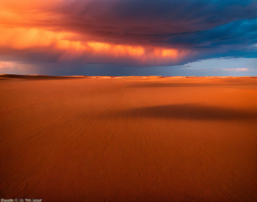 Orange Hues Over Sand Dunes and Dramatic Sky