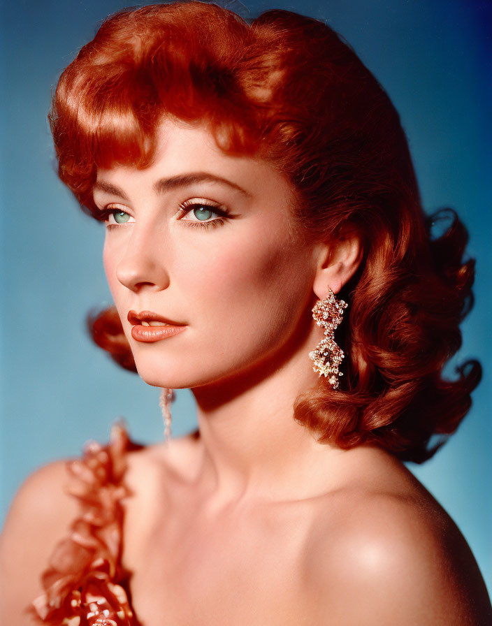 Red-haired woman with vintage waves, blue eyes, and sparkling earrings in ruffled garment.