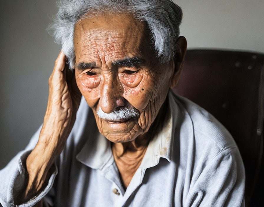 White-Haired Elderly Man with Mustache Looking Somber