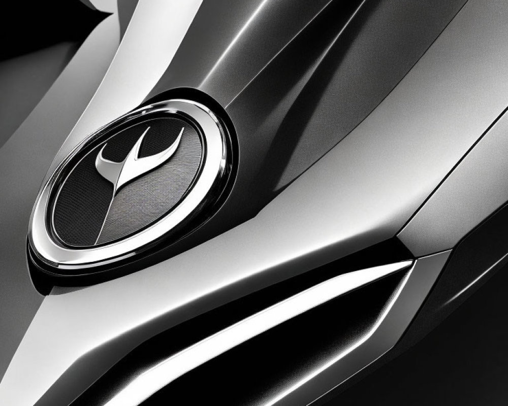 Grayscale close-up of metallic car badge and grille design