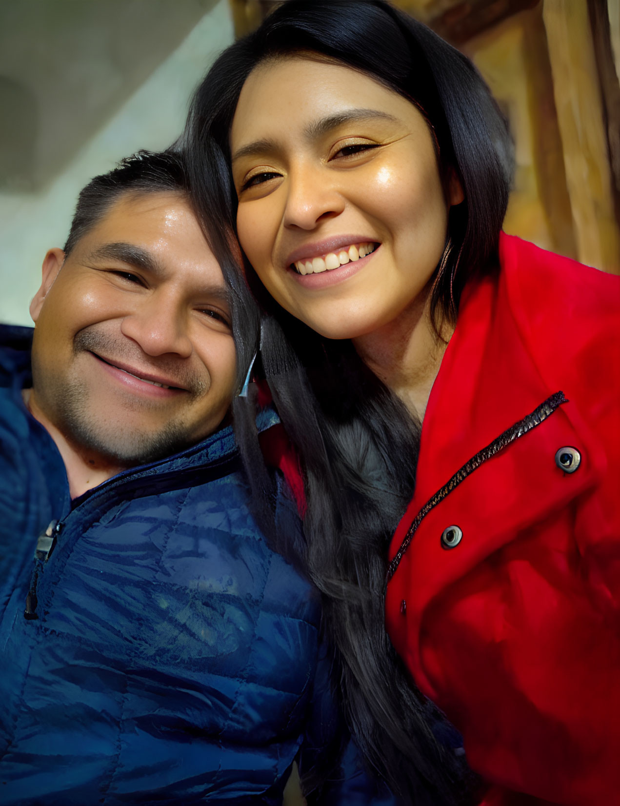 Smiling individuals in blue and red jackets pose together