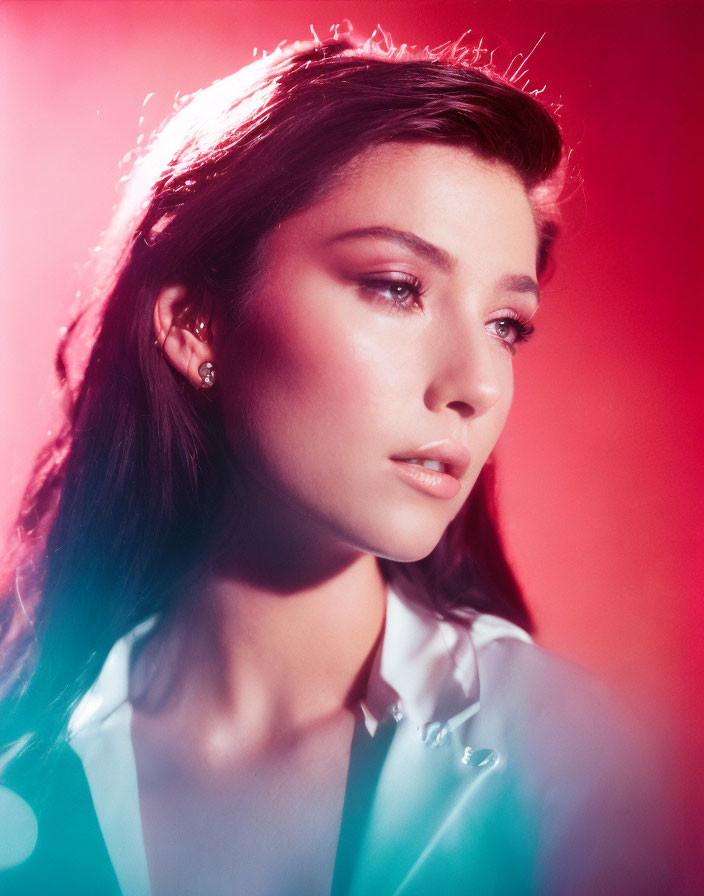 Young woman portrait with soft gaze and red backlit halo effect.