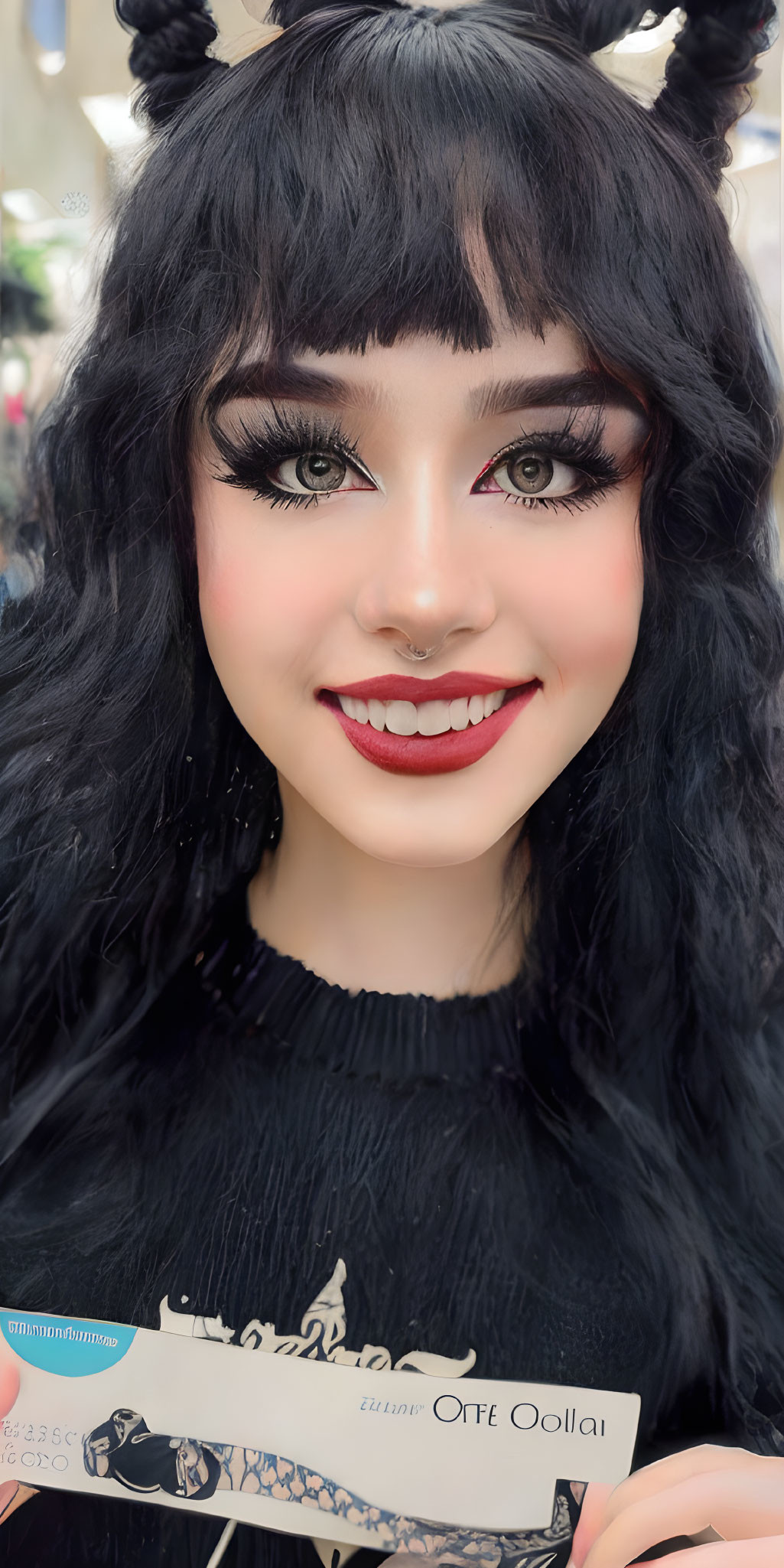 Styled black hair, double buns, nose ring, dramatic makeup: woman smiling with text card