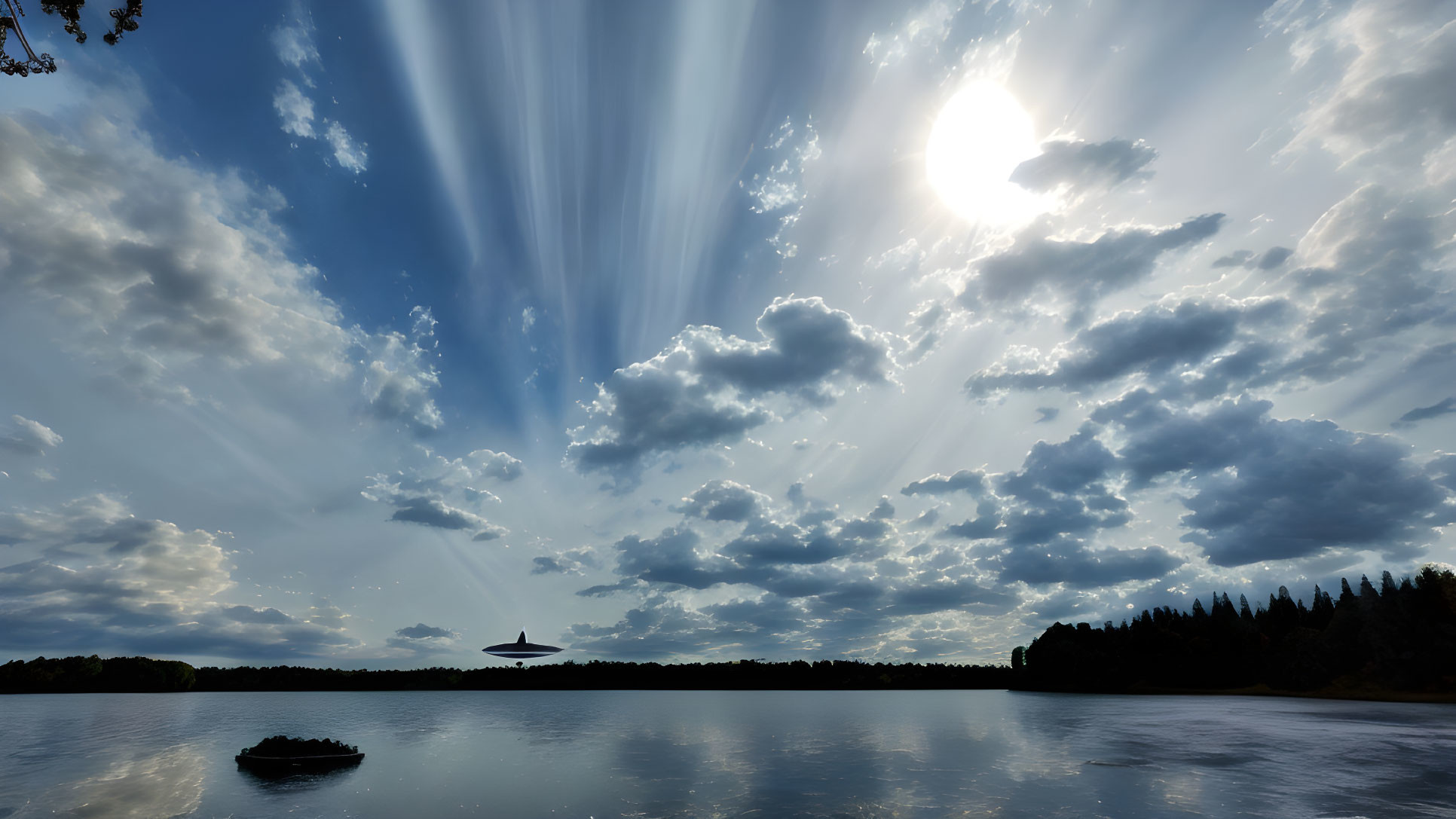 Tranquil lake scene with dramatic sunbeams and lush treeline