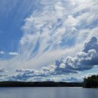 Tranquil sunset scene: serene lake, streaked clouds, birds in flight