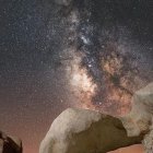 Surreal landscape featuring old ship in cavern under starry sky