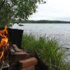 Cozy lakeside cabin with grass-covered roof by serene waters