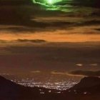 Futuristic cityscape with pyramids under dusky sky and UFO beam