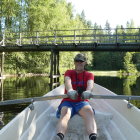 Cloaked figure on futuristic boat in serene waterway