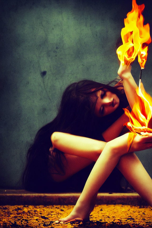 Woman Holding Flame Against Dark Textured Background