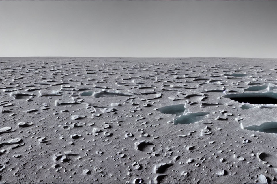 Barren rocky landscape with scattered ice and hazy sky