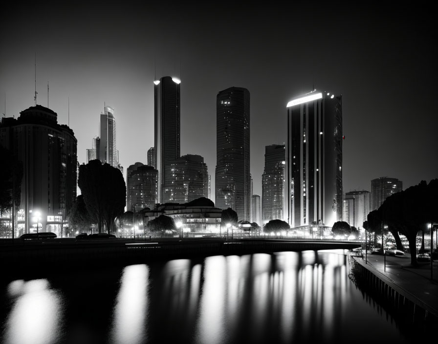 Night cityscape with illuminated skyscrapers reflected in water