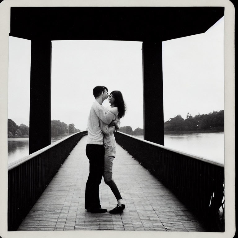 Couple Embraces on Bridge with Water Background in Monochrome Photo