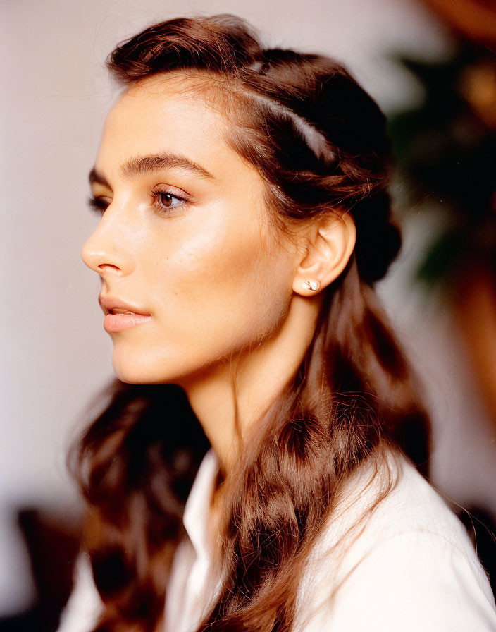 Profile view of woman with braided brown hair and white shirt