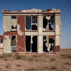 Abandoned red brick building with broken windows against clear sky