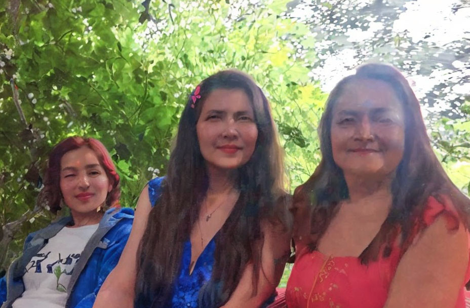 Three women smiling outdoors with trees in background