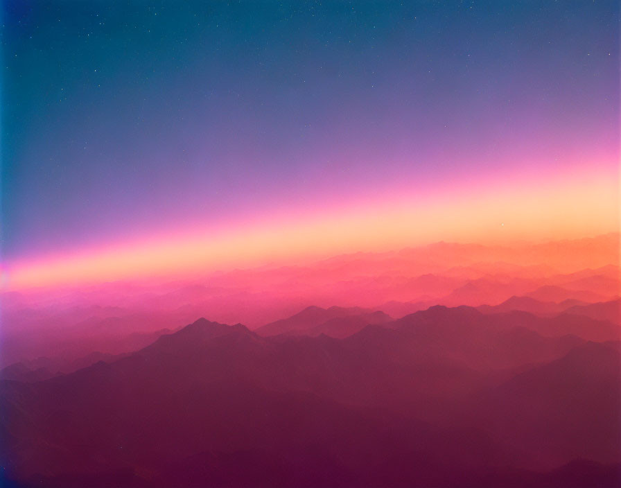 Blue to Pink Gradient Over Layered Mountain Silhouettes at Night