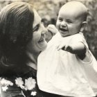 Joyful woman and laughing baby among flowers in monochromatic style