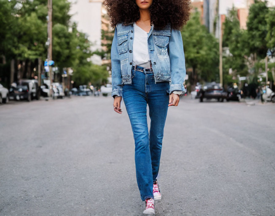 Curly-Haired Person in Denim Walking City Street