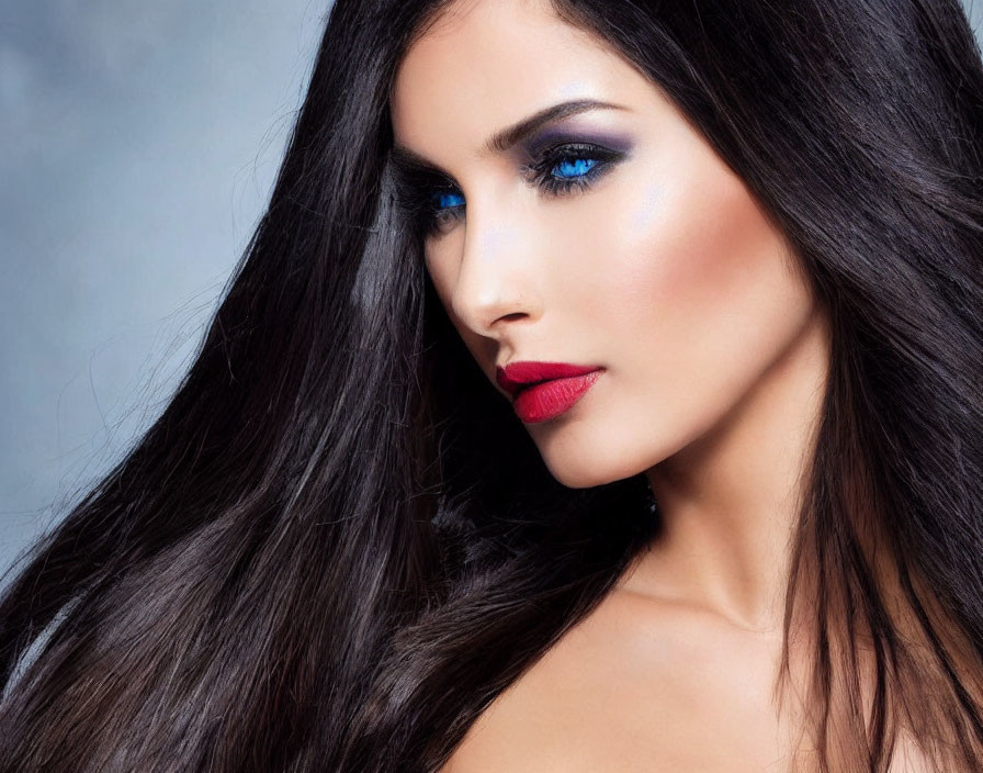 Woman with Long Dark Hair and Striking Makeup on Grey Background